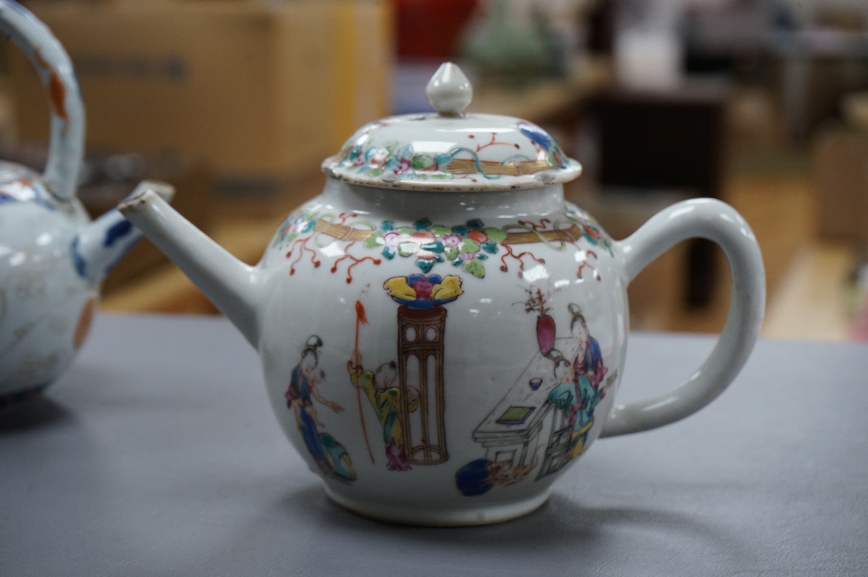 A Chinese famille rose ‘boys and ladies’ teapot, Qianlong period and a Japanese Arita sake pot or ewer, early 18th century, tallest 16cm high.